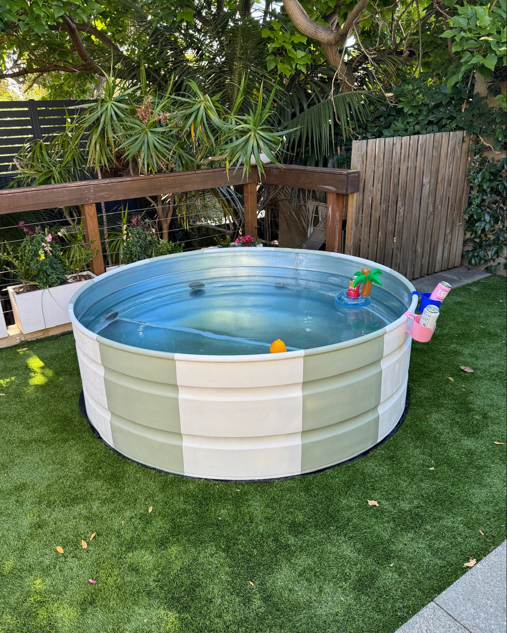 stock tank pool with toys on a grassy lawn