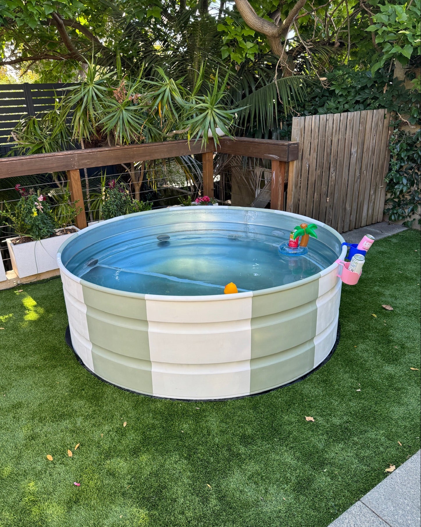 stock tank pool with toys on a grassy lawn