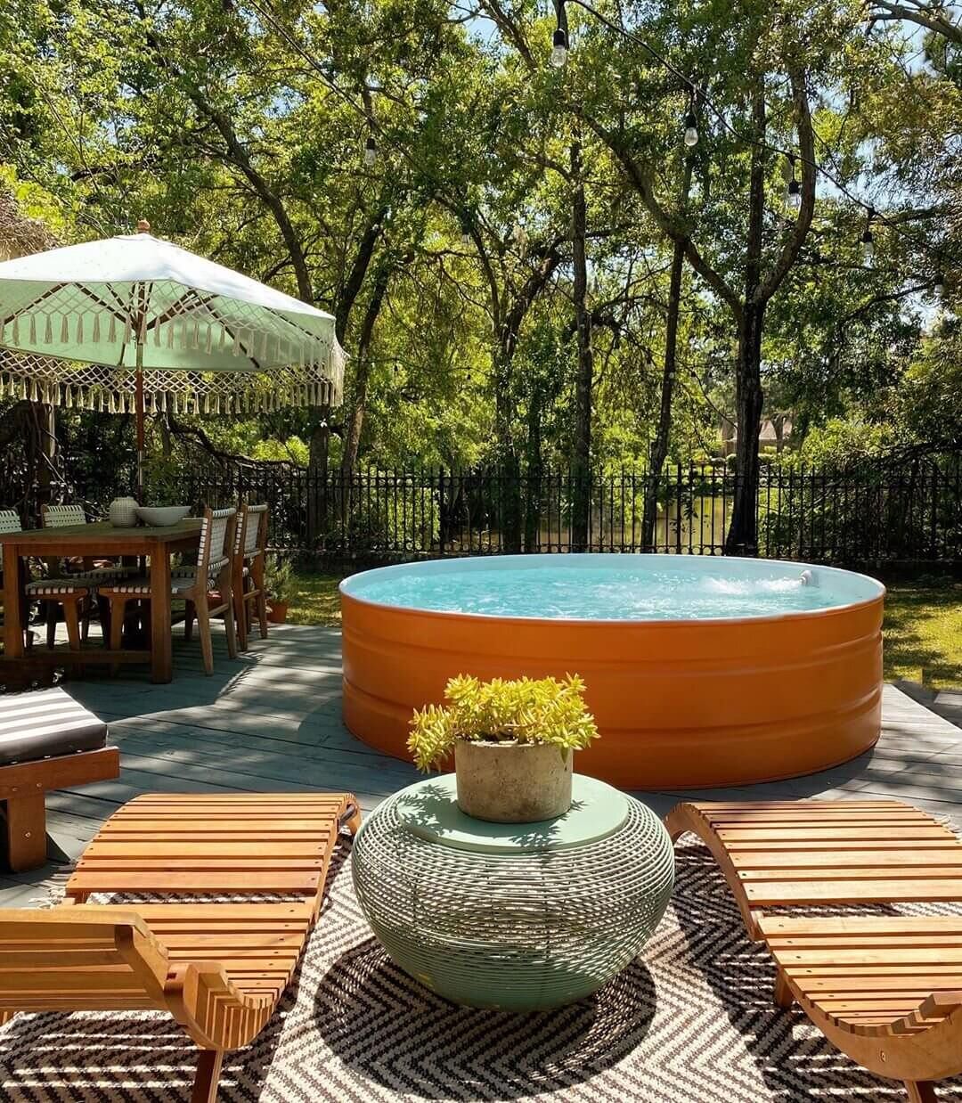 Orange inflatable pool in a backyard setting with outdoor furniture and greenery.