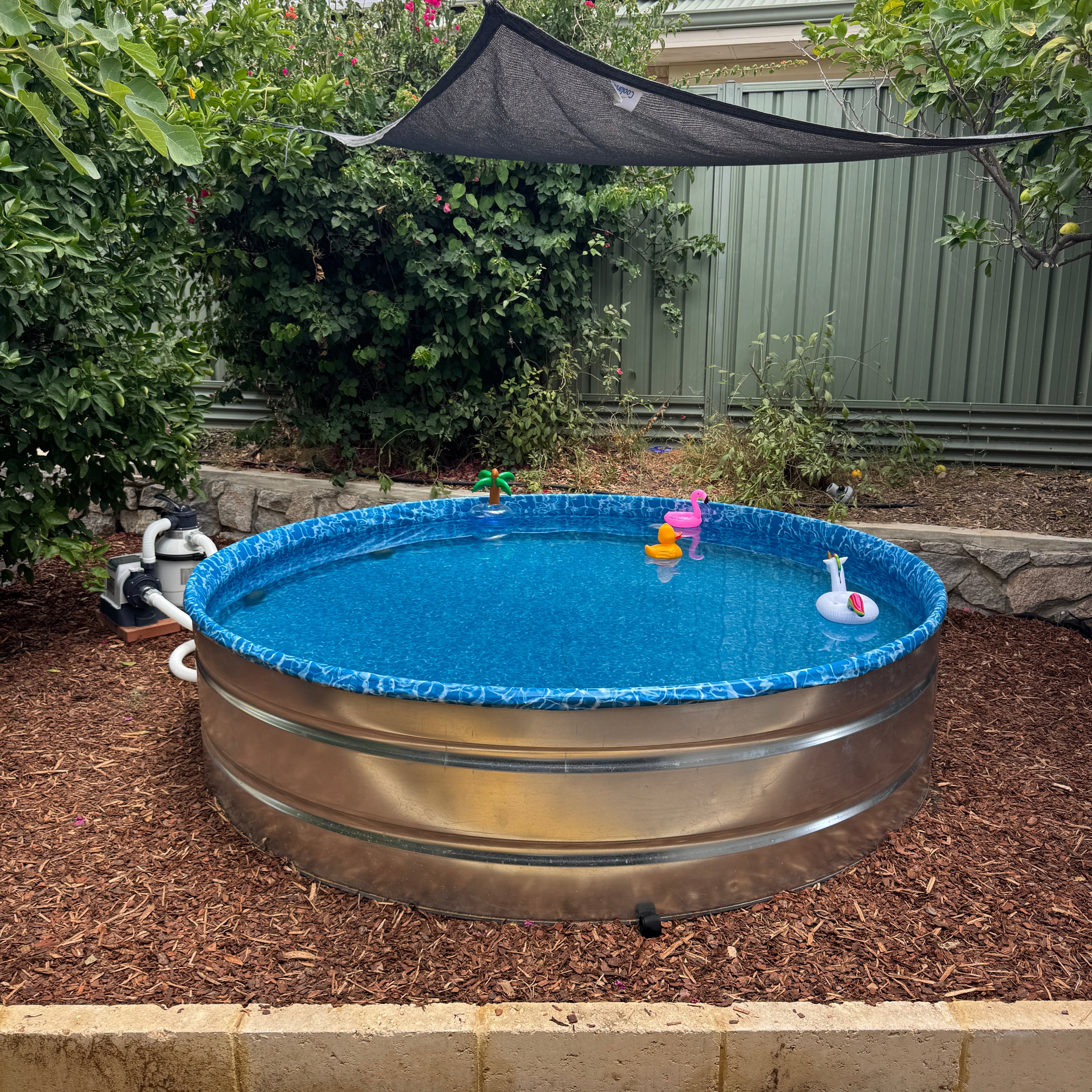stock tank pool in a backyard with a linler