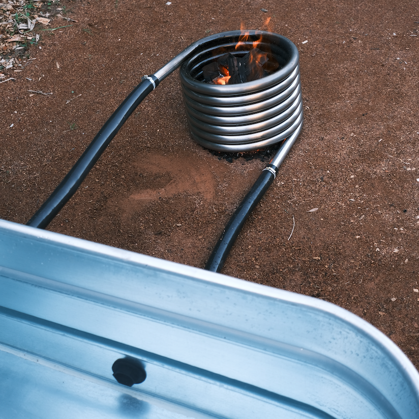 Off grid wood fired coil kit with fire close up with tub